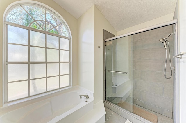 bathroom with shower with separate bathtub and a textured ceiling