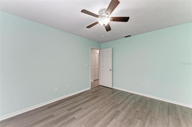 unfurnished room with ceiling fan, a textured ceiling, and light wood-type flooring