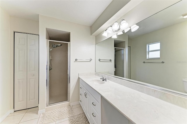 bathroom with toilet, vanity, a shower with door, and tile patterned flooring