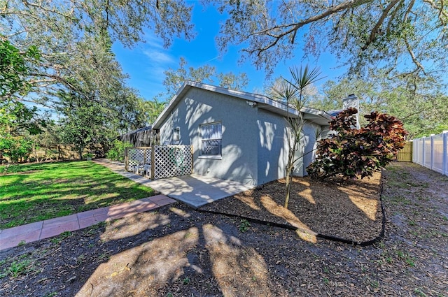 view of side of property with a yard and a patio area