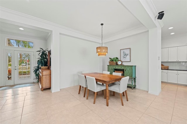dining area with light tile patterned floors and ornamental molding