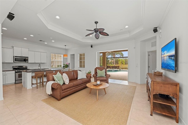 living room with light tile patterned floors, ornamental molding, a raised ceiling, and a healthy amount of sunlight