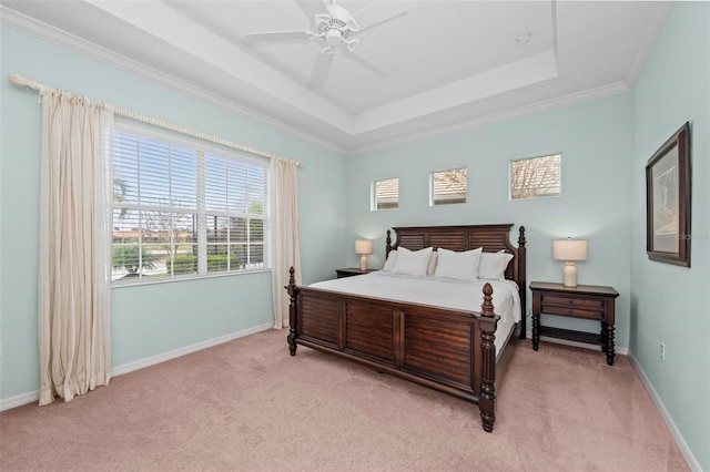 bedroom with ceiling fan, ornamental molding, light carpet, and a tray ceiling