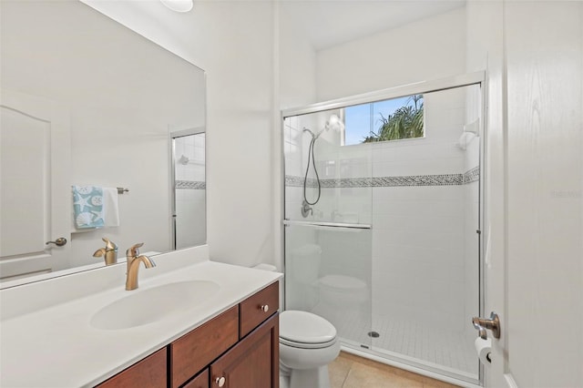 bathroom with a shower with shower door, tile patterned floors, toilet, and vanity