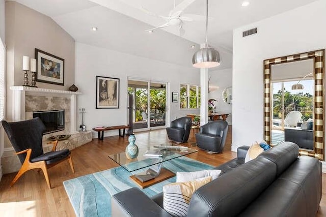 living room featuring hardwood / wood-style flooring, lofted ceiling, and a high end fireplace