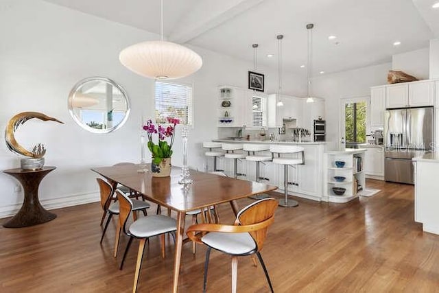 dining area with beam ceiling and hardwood / wood-style floors