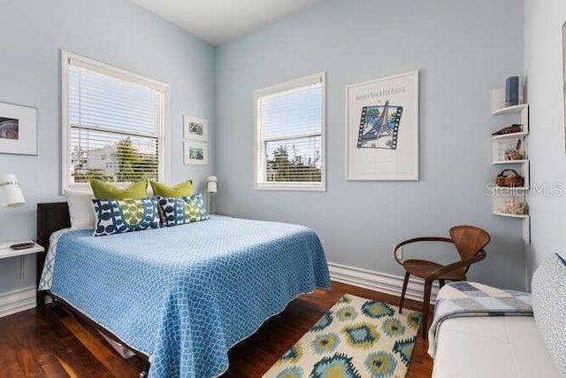 bedroom featuring dark wood-type flooring and multiple windows