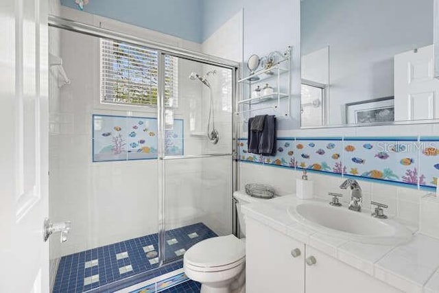 bathroom with vanity, toilet, and a shower with door