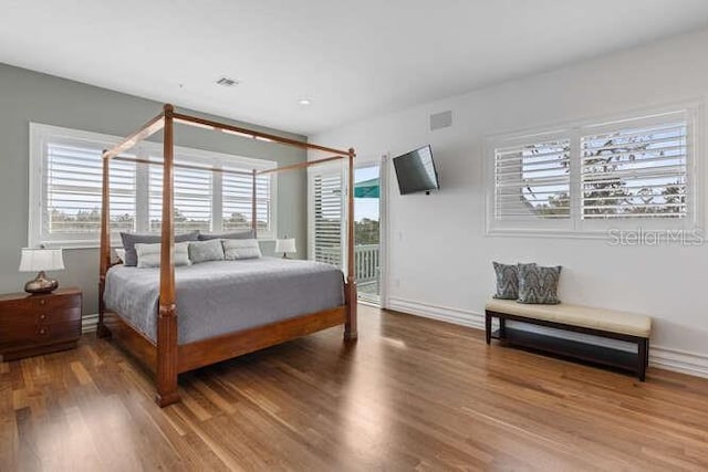 6821 Longboat Dr S, Longboat Key, FL 34228 - bedroom with wood finished floors, baseboards, and access to outside