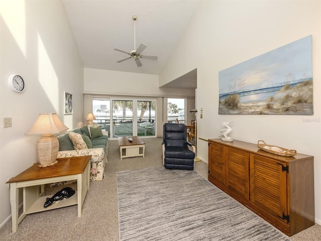 carpeted living room featuring high vaulted ceiling and ceiling fan