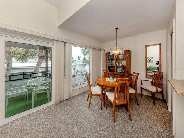 carpeted dining room featuring a notable chandelier