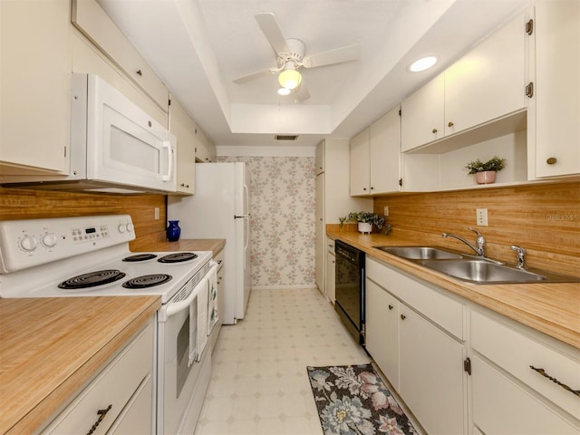 kitchen featuring a raised ceiling, sink, white cabinets, tasteful backsplash, and white appliances