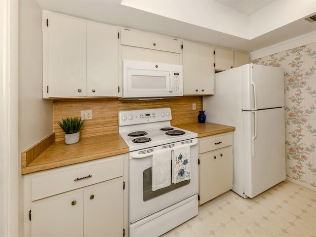 kitchen featuring white appliances, decorative backsplash, and white cabinets