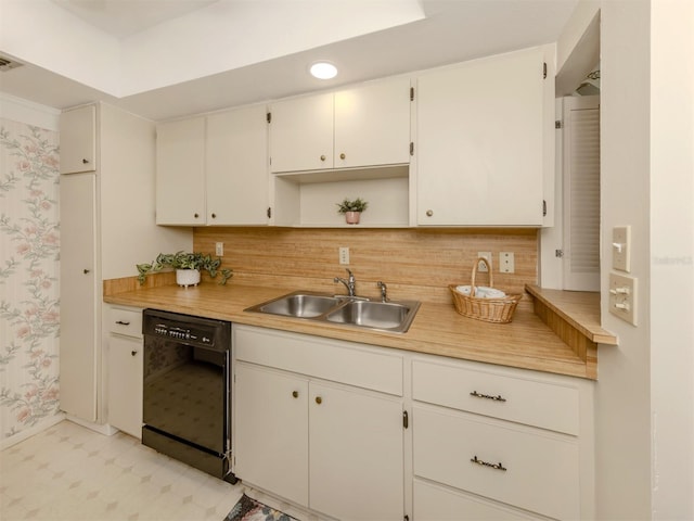 kitchen featuring sink, backsplash, white cabinetry, and black dishwasher