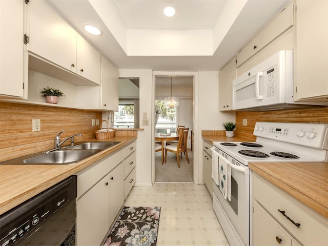 kitchen featuring sink, white appliances, and white cabinets