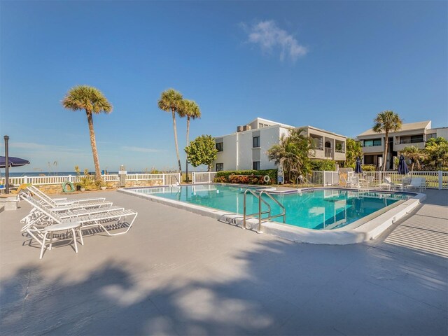 view of swimming pool with a water view and a patio area