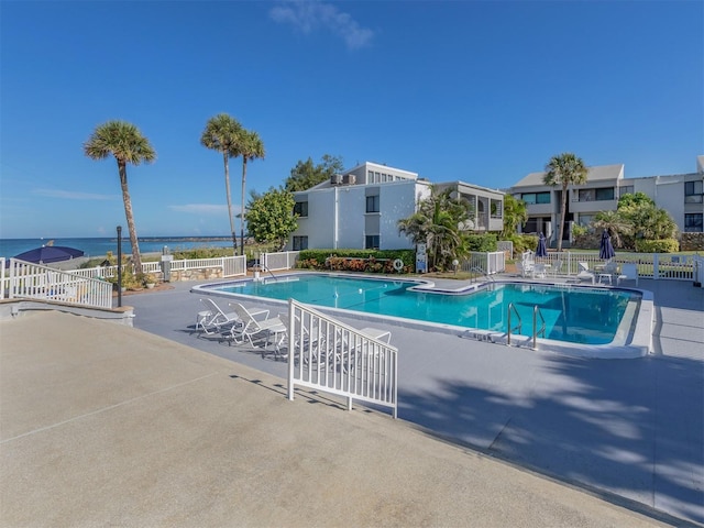 view of pool featuring a patio area and a water view