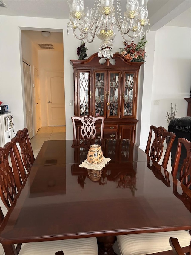 tiled dining room with a notable chandelier