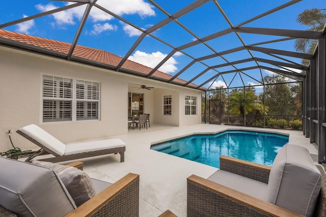 pool with glass enclosure, an outdoor living space, ceiling fan, and a patio area