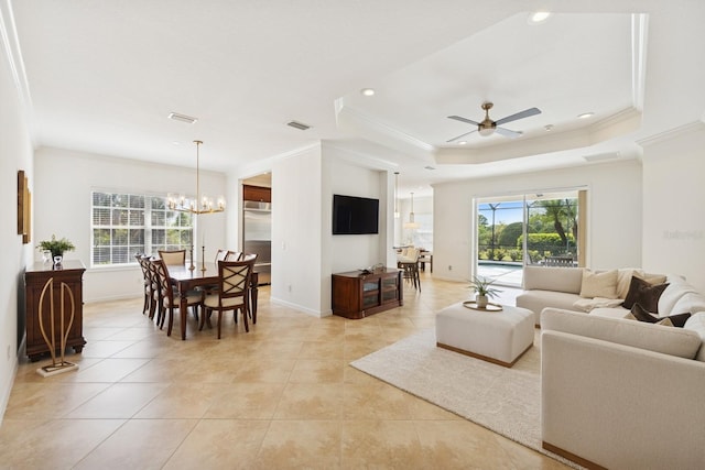 living room with ceiling fan with notable chandelier, crown molding, and a healthy amount of sunlight