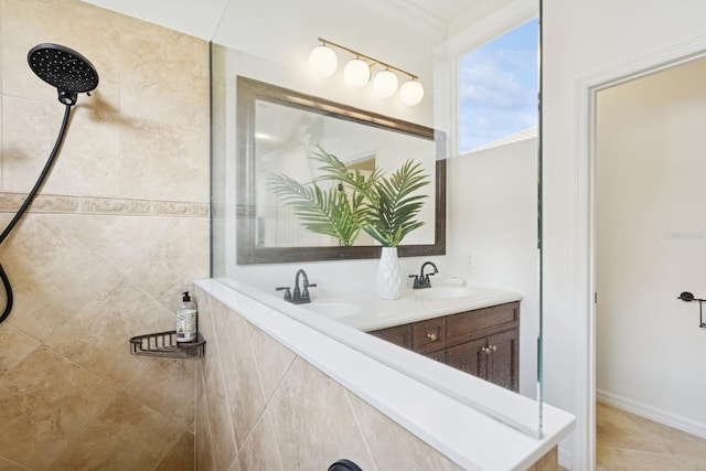 bathroom with double vanity, a sink, ornamental molding, and a tile shower