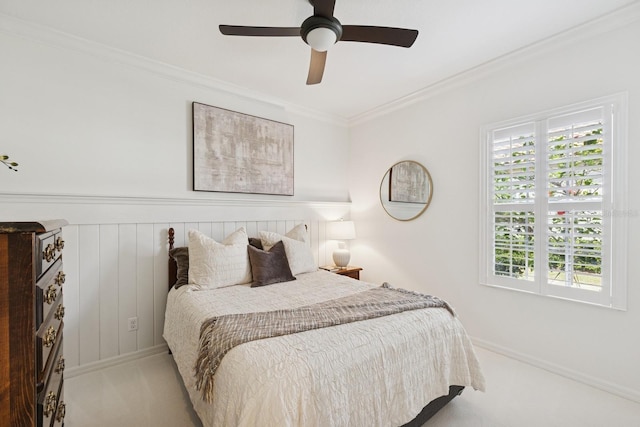 carpeted bedroom featuring ornamental molding and a ceiling fan