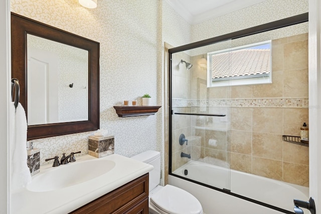 bathroom featuring wallpapered walls, vanity, shower / bath combination with glass door, and toilet