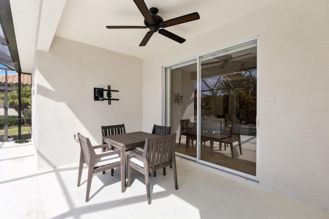 view of patio featuring outdoor dining space, a lanai, and a ceiling fan