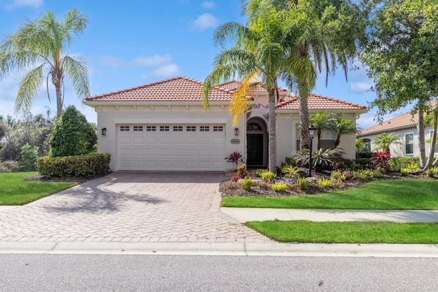 mediterranean / spanish-style house featuring stucco siding, driveway, a garage, and a tiled roof