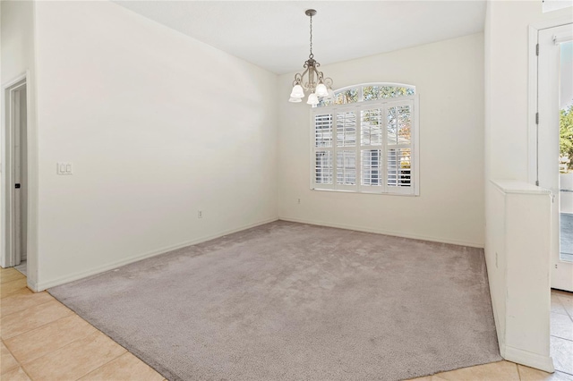 unfurnished room featuring an inviting chandelier and light colored carpet