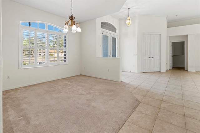 carpeted spare room with a chandelier and vaulted ceiling