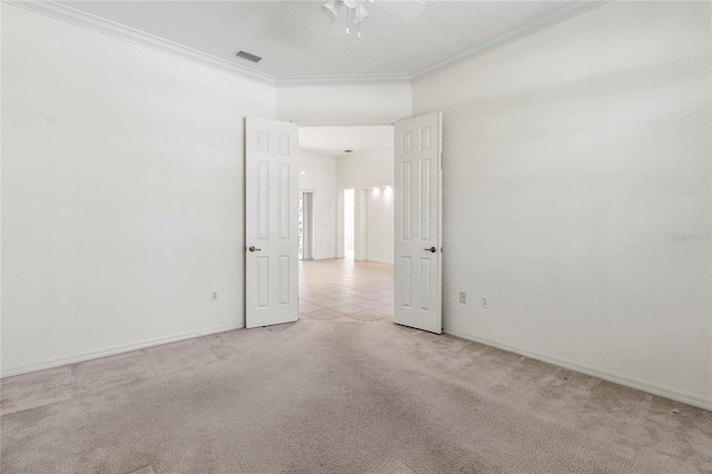 empty room featuring ornamental molding, light colored carpet, and ceiling fan