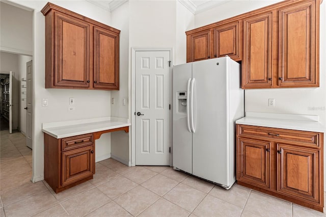 kitchen with light tile patterned floors, ornamental molding, and white fridge with ice dispenser