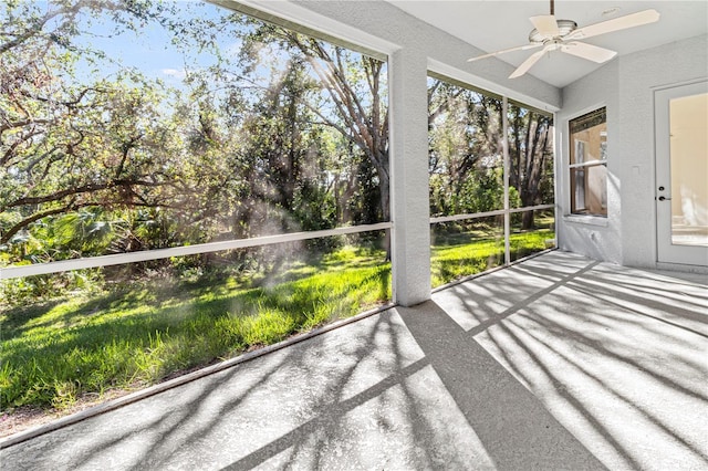 unfurnished sunroom with ceiling fan