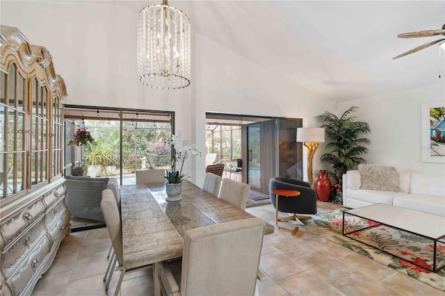 tiled dining room with ceiling fan with notable chandelier and high vaulted ceiling