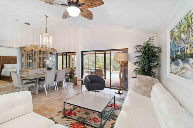 living room featuring ceiling fan with notable chandelier, lofted ceiling, and light tile patterned floors