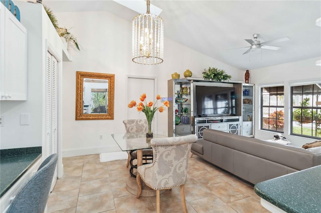 tiled living room featuring ceiling fan with notable chandelier and vaulted ceiling