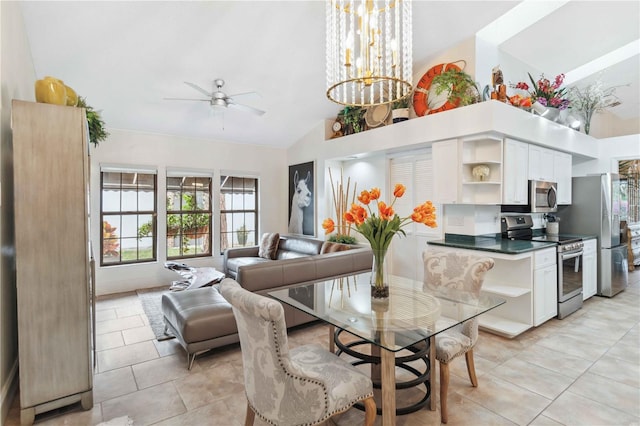 dining room with ceiling fan with notable chandelier, vaulted ceiling, and light tile patterned floors