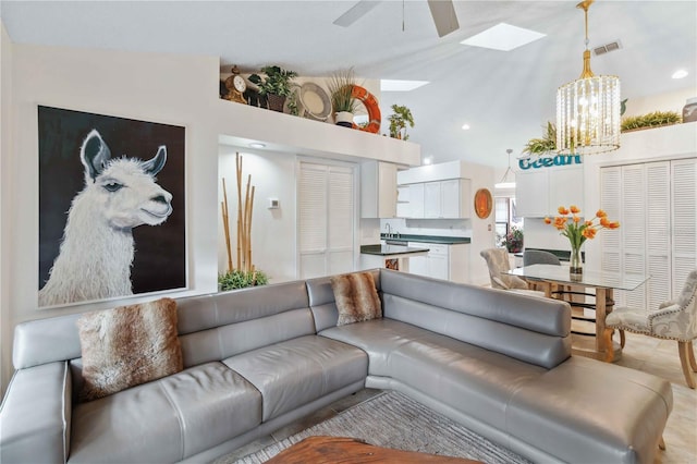 living room with lofted ceiling and ceiling fan with notable chandelier