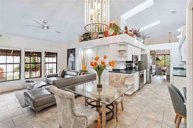 dining space featuring light tile patterned flooring, lofted ceiling, and ceiling fan with notable chandelier