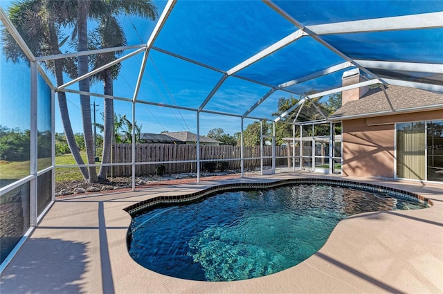 view of swimming pool featuring a patio and glass enclosure