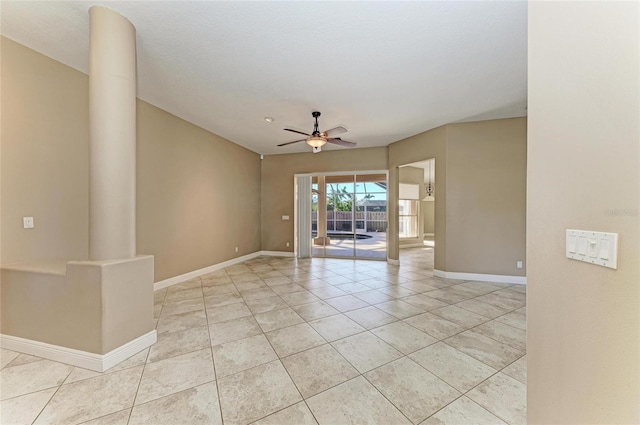 unfurnished room with light tile patterned floors, ceiling fan, and ornate columns