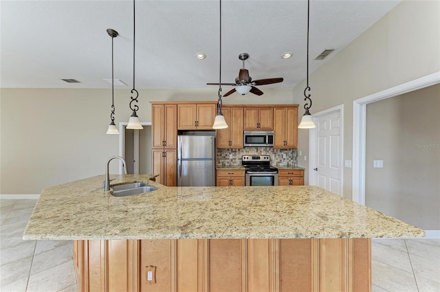 kitchen with appliances with stainless steel finishes, decorative light fixtures, tasteful backsplash, sink, and a spacious island