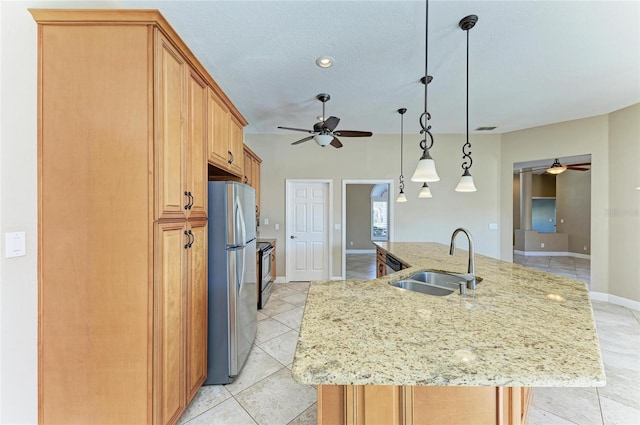 kitchen with appliances with stainless steel finishes, sink, a center island with sink, and decorative light fixtures