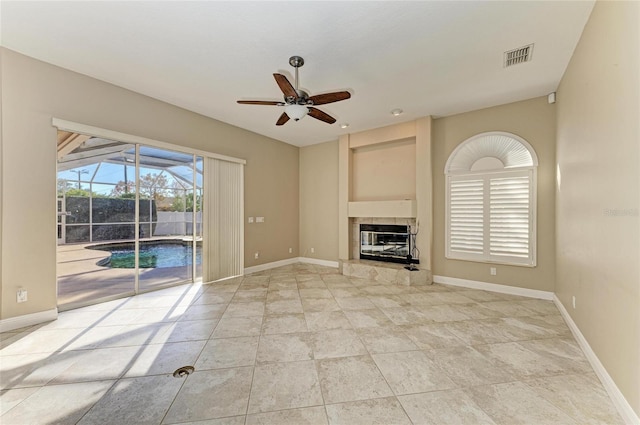 unfurnished living room featuring ceiling fan and a fireplace