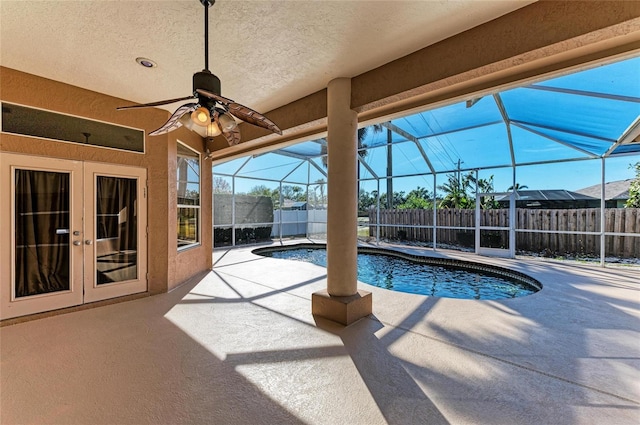 view of swimming pool with french doors, ceiling fan, a lanai, and a patio