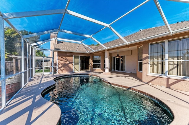 view of swimming pool with glass enclosure and a patio