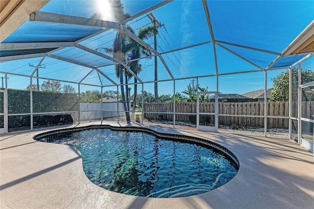 view of pool with a patio area and glass enclosure