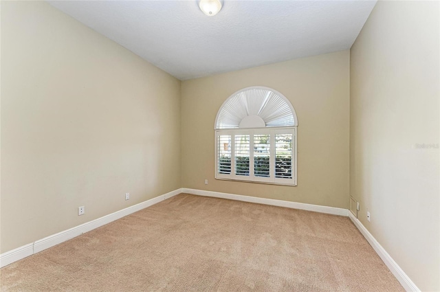 unfurnished room featuring light carpet