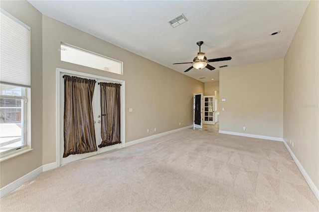 unfurnished room featuring ceiling fan, light colored carpet, and a textured ceiling